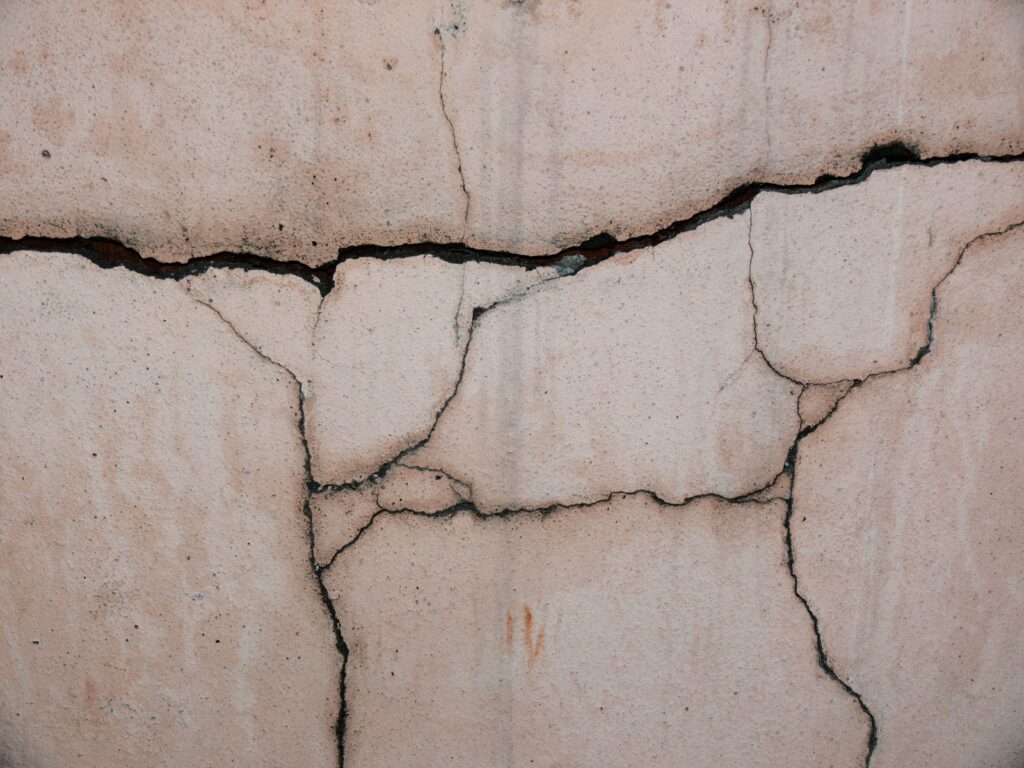 Close-up of a cracked concrete wall showing foundation warning signs