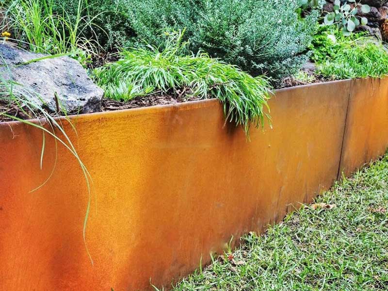 Corten steel retaining wall used as a low garden retaining wall with plants