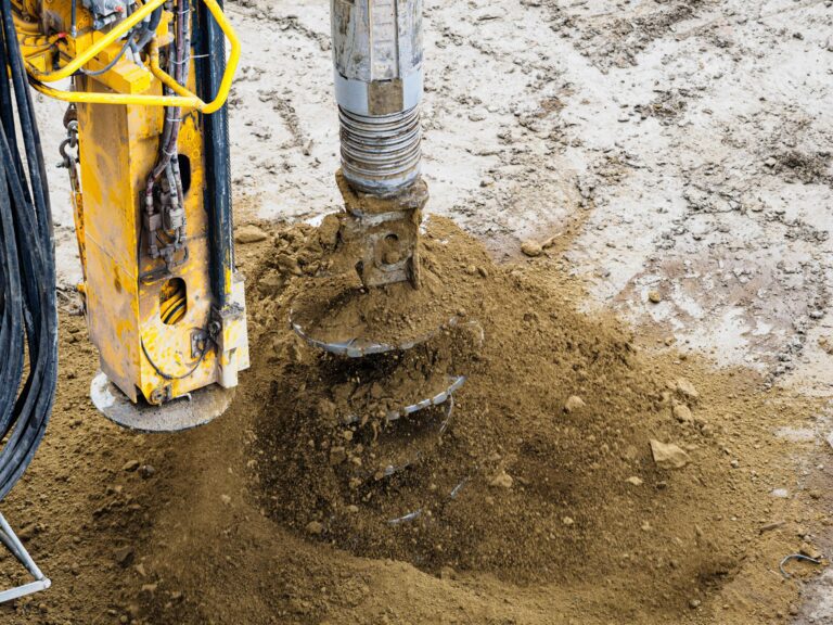Deep foundation drilling equipment forming a bored pile in soil