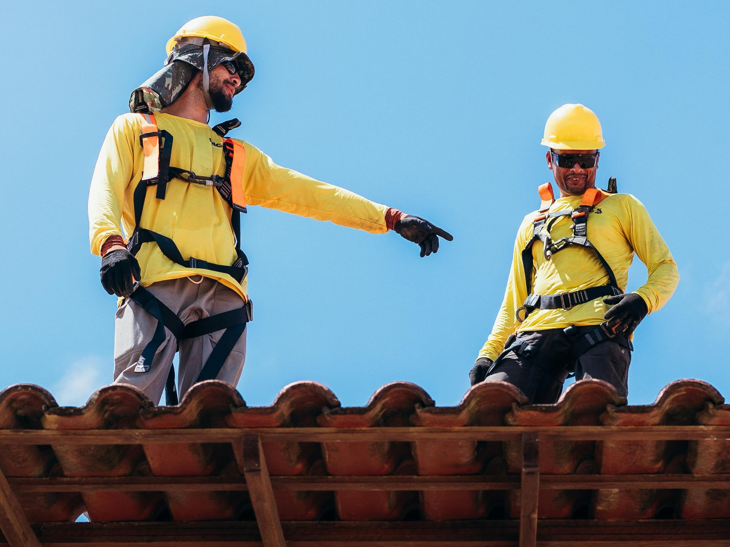 Roofing professionals inspecting a tile roof in a hot dry climate