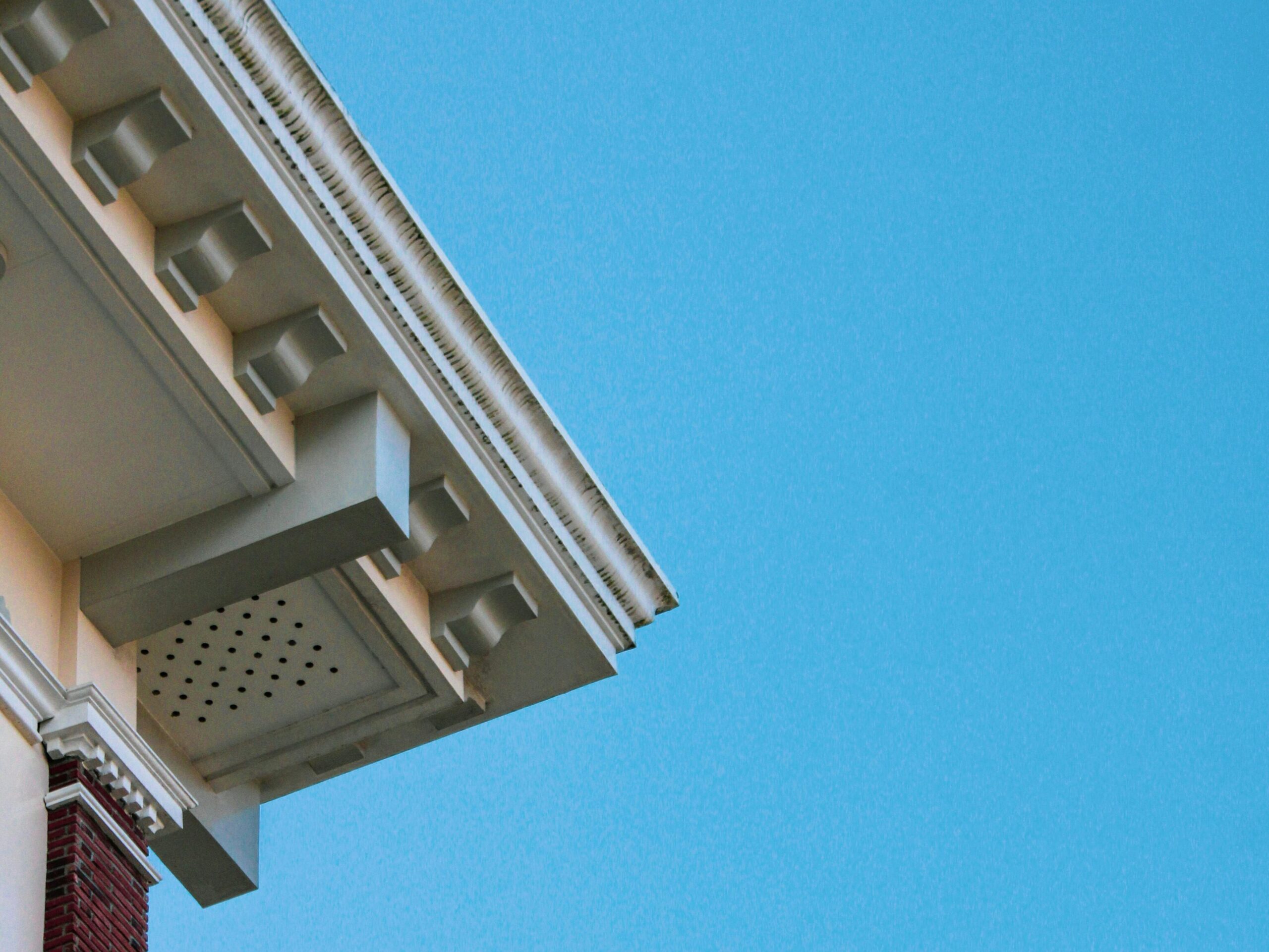 Vented soffit panel under a residential roof eave